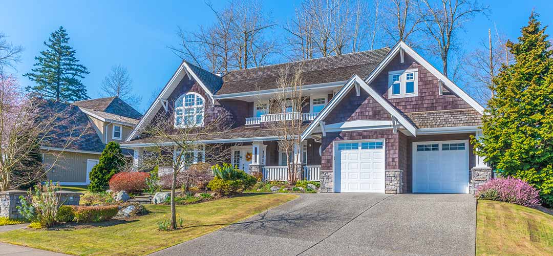 Pretty residential house with two garages and beautiful landscaping.